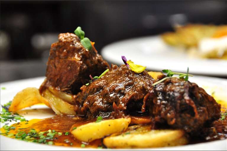 Carrilleras de cerdo guisada al aroma del Somontano y patatas panadera.