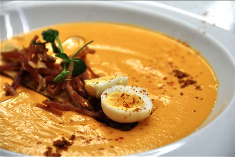 Salmorejo de la casa con su huevo de codorniz, virutas de jamoncito picado y picatostes.
