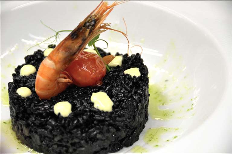 Arroz negro de sepia con alioli y gamba.