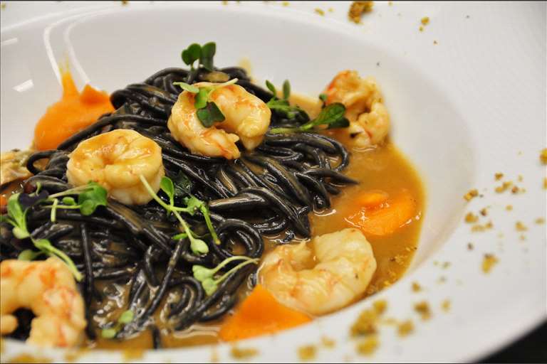 Sphaguetti al nero di seppia con salsa marinera y frutos del mar, emulsión de boniato y polvo de pistacho.