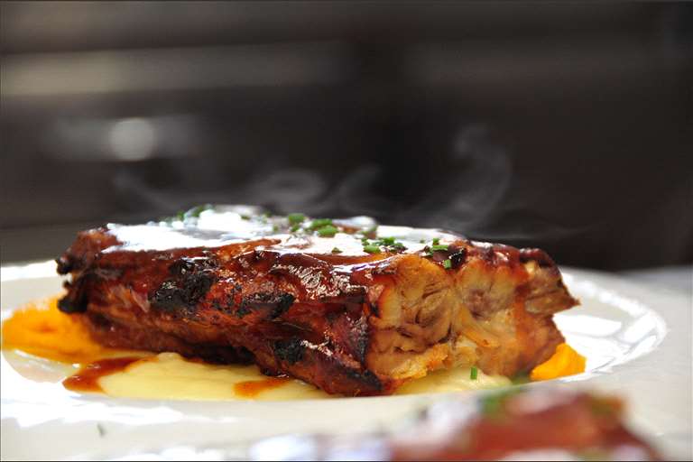 Costilla de cerdo a baja temperatura y asada, con salsa barbacoa de casa.